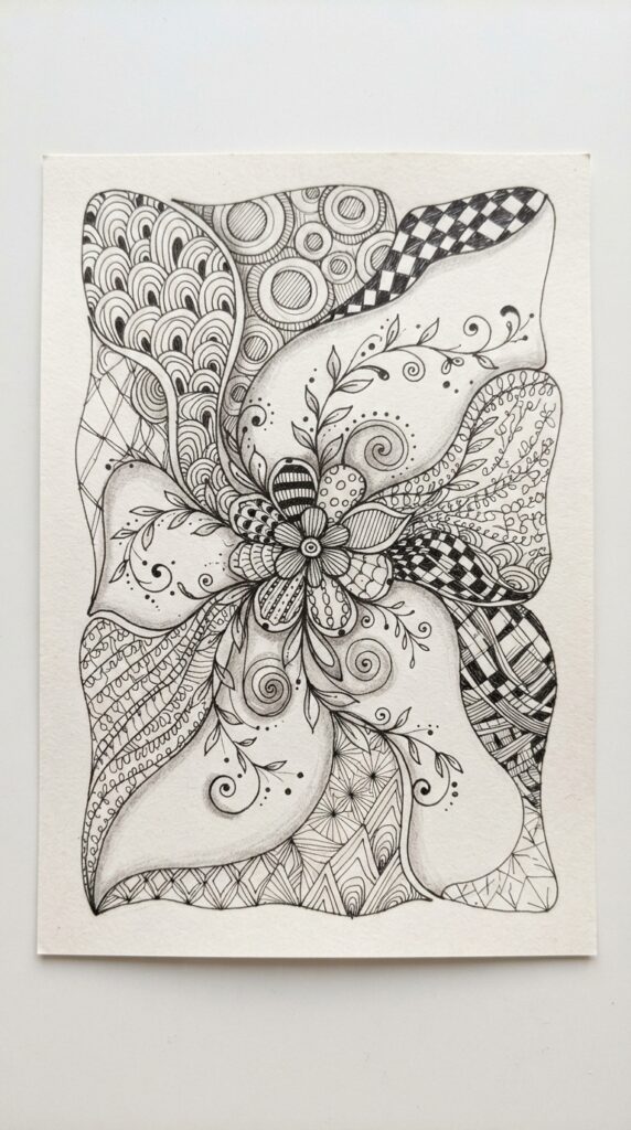 Finished beginner Zentangle artwork with flowers, leaves, spirals, and patterns